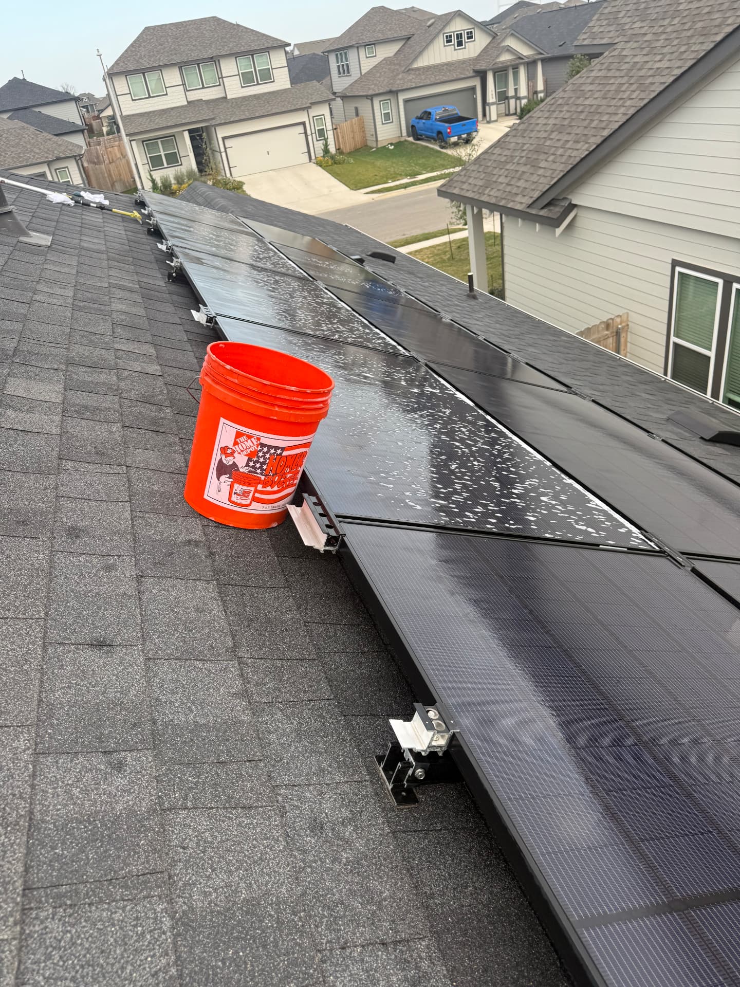 Soapy suds across a Kyle rooftop solar array mid-wash