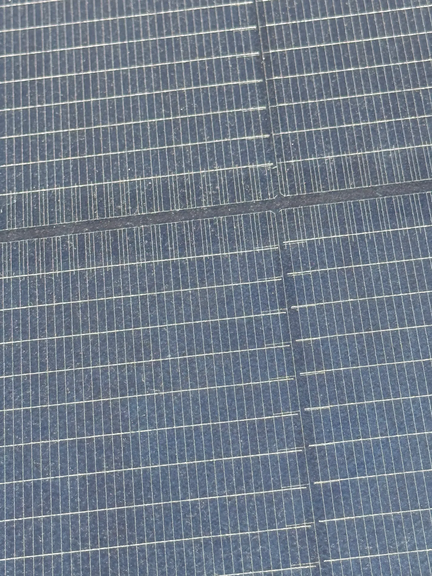 Close-up of a solar panel in Kyle covered in caliche dust and pollen film before cleaning
