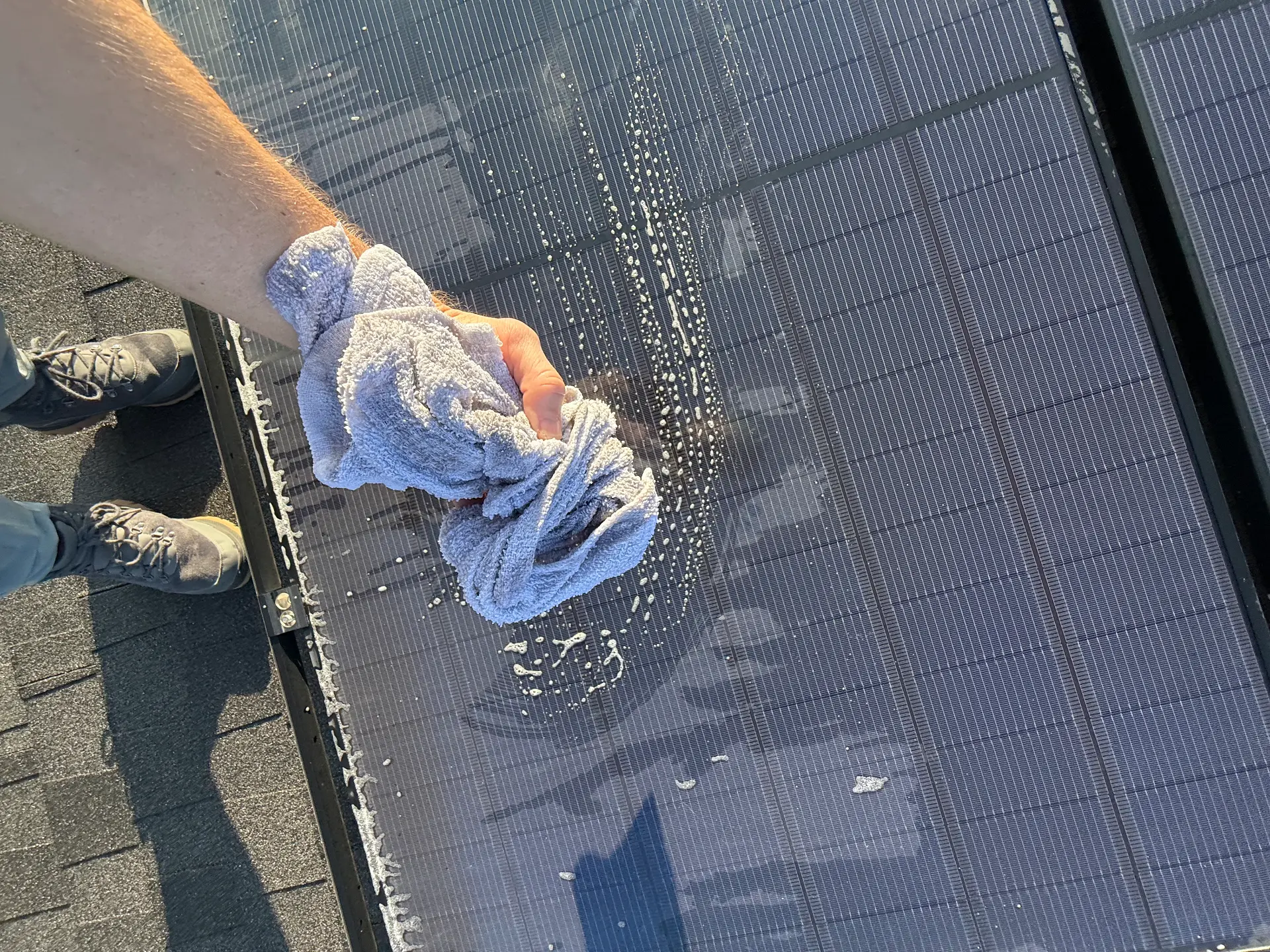 Hand wiping a solar panel with a soft microfiber cloth